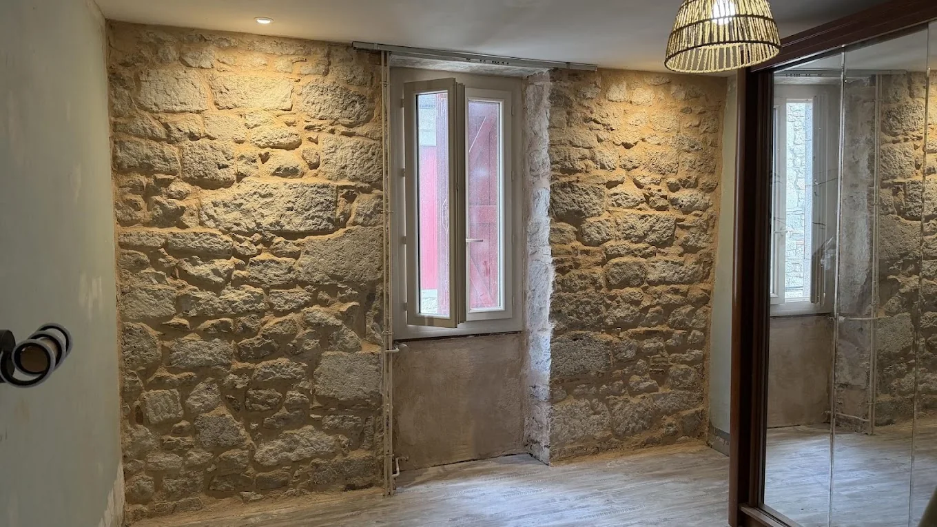 Pièce rénovée avec murs en pierre et finitions propres